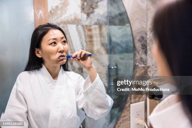 woman brushing her teeth in hotel - real body fotografías e imágenes de stock