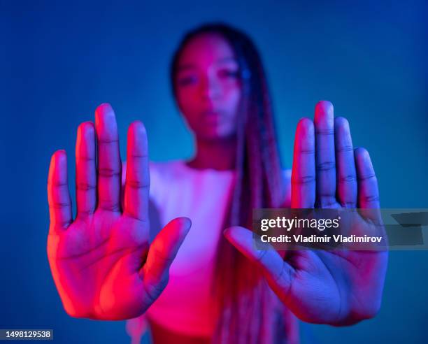 uma mulher étnica mostra palma demonstrar protesto - sinal de parar - fotografias e filmes do acervo