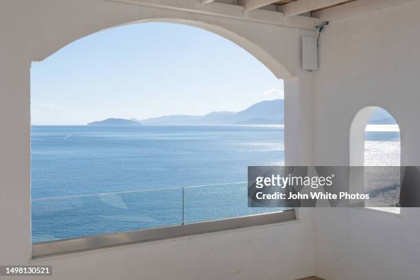 window looking over the aegean sea. crete. greece. - iglesia de agios nikolaos fotografías e imágenes de stock