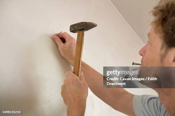 man hammer nail wall portrait close-up - hammer hitting stock pictures, royalty-free photos & images