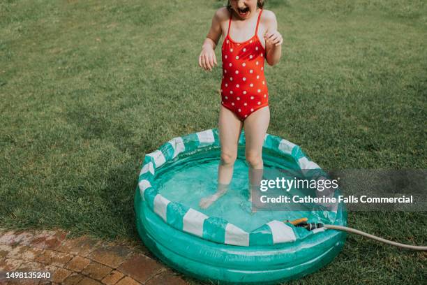 a child in a paddling pool - manguera fotografías e imágenes de stock