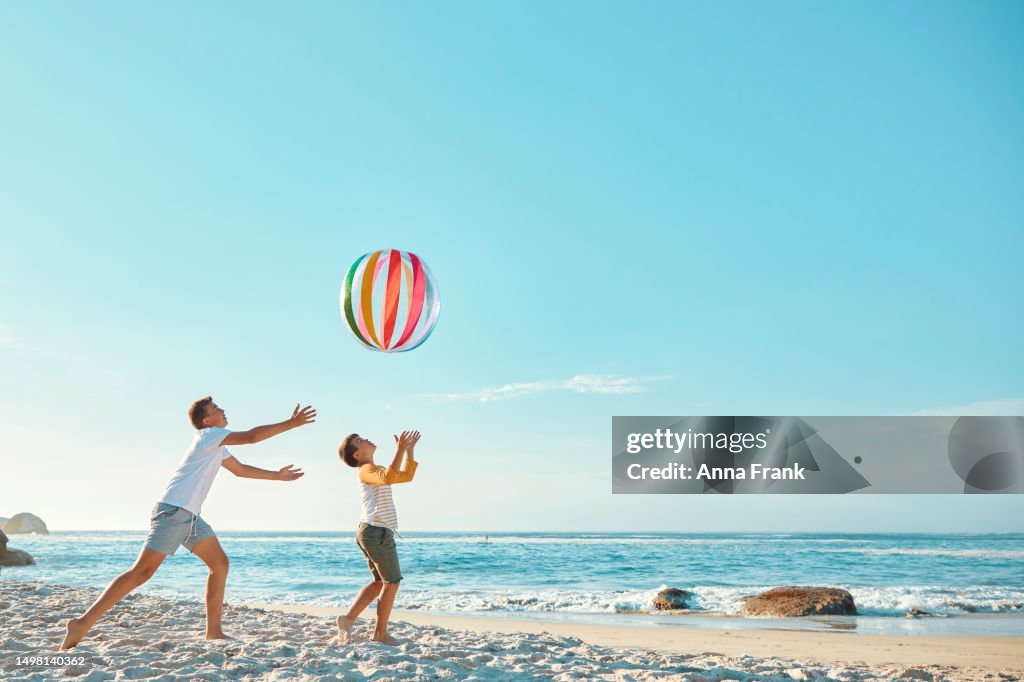 Fratelli che giocano con una palla in spiaggia