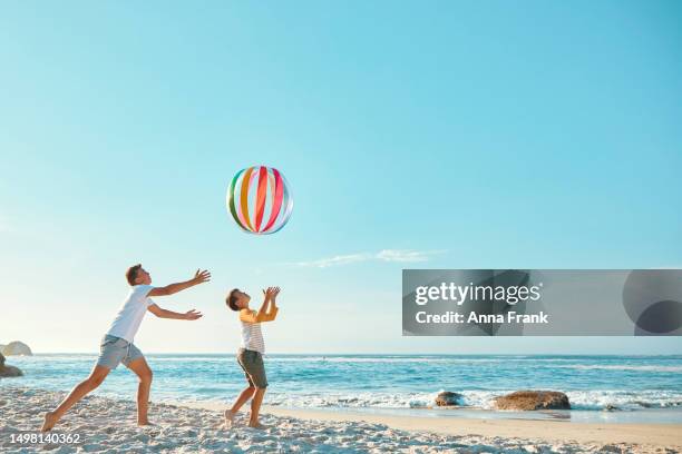 brothers playing with a ball at the beach - blue sky friends stock pictures, royalty-free photos & images