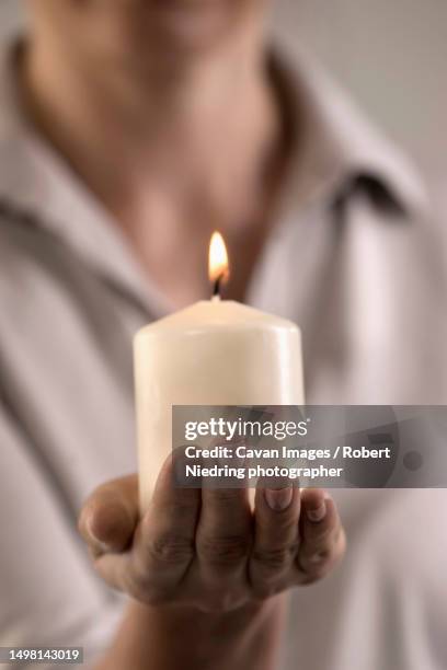 woman holding burning candle in hand, bavaria, germany - mourning candle stock pictures, royalty-free photos & images