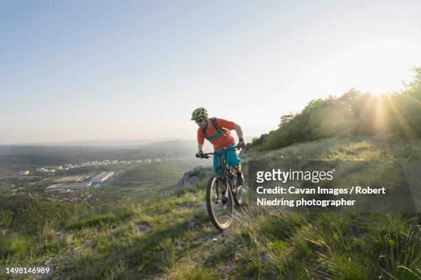 mature man riding mountain bike on mountain - pioneer photographer of motion stock pictures, royalty-free photos & images