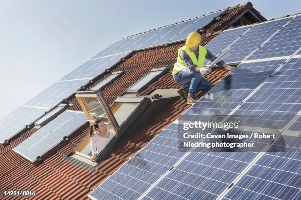 engineer and client on rooftop discussing about solar panels - solpanel bildbanksfoton och bilder