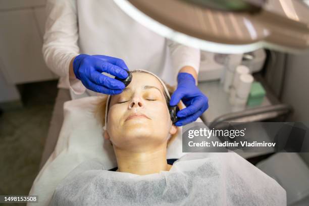 a soothing facial using warm smooth stones - hyperpigmentation stockfoto's en -beelden