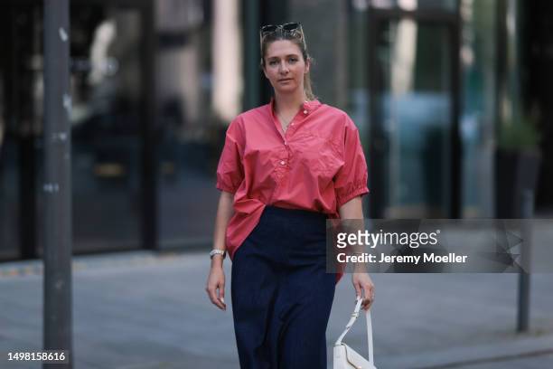 Josephine Kröger seen wearing blue SoSue long skirt, red SoSue oversized blouse, beige small Celine bag on June 08, 2023 in Hamburg, Germany.
