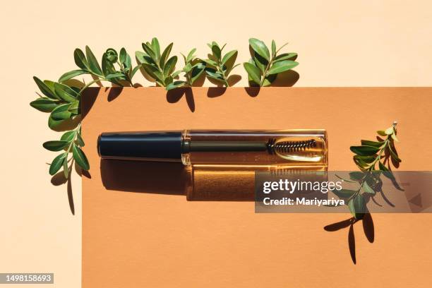 revitalizing oil for eyebrows and eyelashes on a beige background with green leaves. - thick stock pictures, royalty-free photos & images