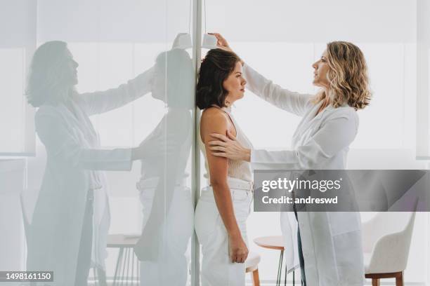 診療所で身長を測定する女性 - height ストックフォトと画像