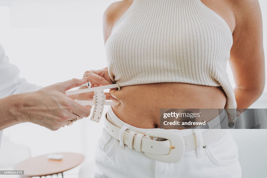 Woman measuring human arm body fat