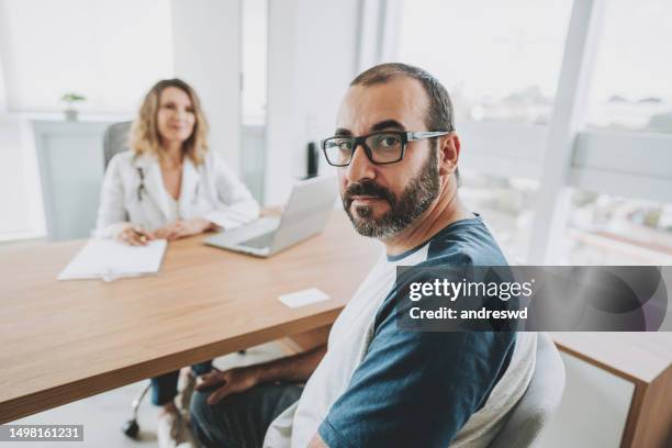 portrait of a serious male patient at the doctor's office - doctor looking at camera stock pictures, royalty-free photos & images