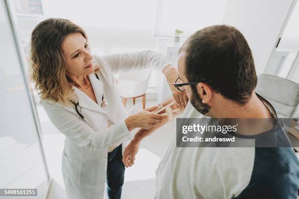 portrait of female doctor measuring patient's upper arm fat - menselijke arm stockfoto's en -beelden