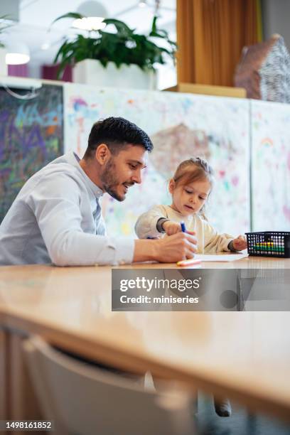 un père joyeux et sa petite fille dessinent avec des marqueurs à la crèche - girl business photos et images de collection