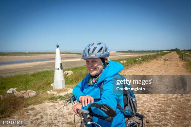 active female senior with bicycle and helmet - cycling helmet stock pictures, royalty-free photos & images