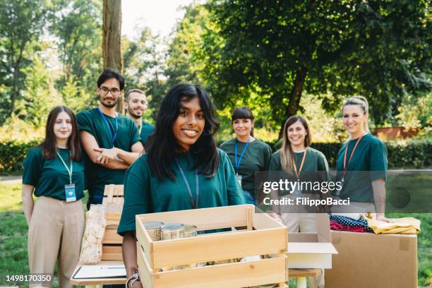 portrait of a volunteer holding a donation box - man holding donation box stock pictures, royalty-free photos & images