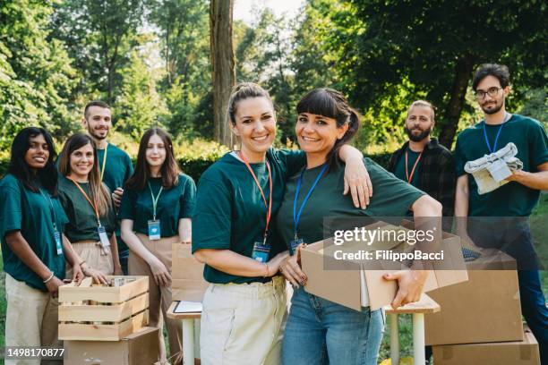 portrait of two volunteers holding a donation box - man holding donation box stock pictures, royalty-free photos & images