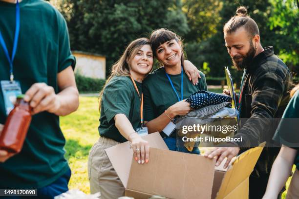 volunteers are preparing donation boxes at the food and clothes bank - man holding donation box stock pictures, royalty-free photos & images