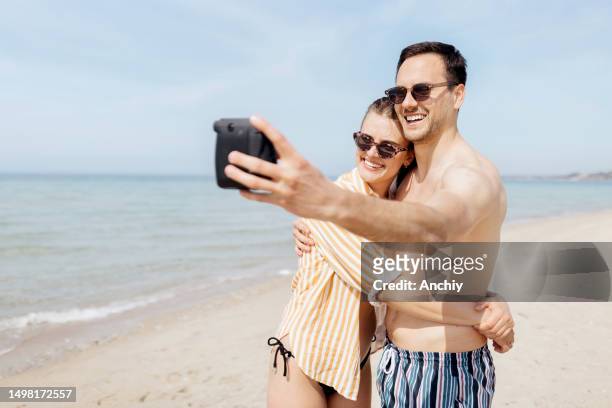 couple taking a polaroid picture - tourist selfie stock pictures, royalty-free photos & images