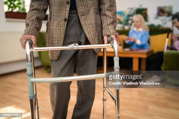 eine behinderte person, die einen rollator benutzt - residential care stock-fotos und bilder