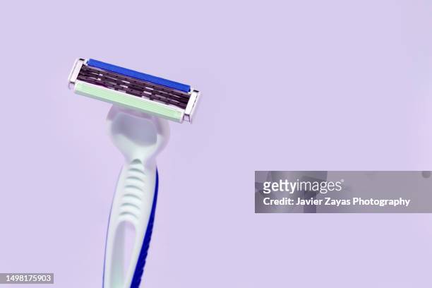 pink razor blade on purple background - safety shave razor stock-fotos und bilder
