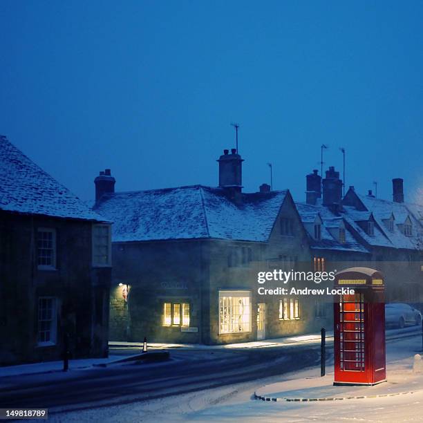english red telephone booth, in snow - illuminated house stock pictures, royalty-free photos & images