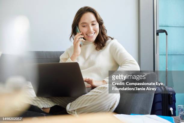 young woman using smart phone in hotel room - business woman suitcase stock pictures, royalty-free photos & images