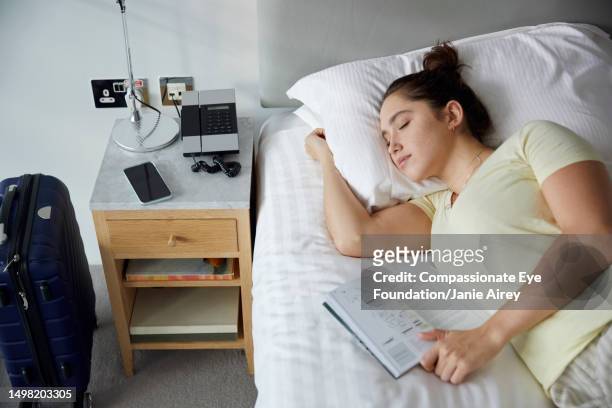 young woman having sleep in hotel room - hotel room white bed stock pictures, royalty-free photos & images