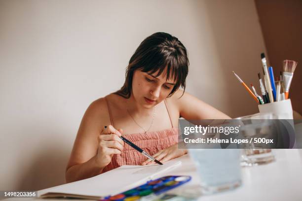 portrait of a young woman painting on paper at table at home,belo horizonte,state of minas gerais,brazil - aquarela stock pictures, royalty-free photos & images