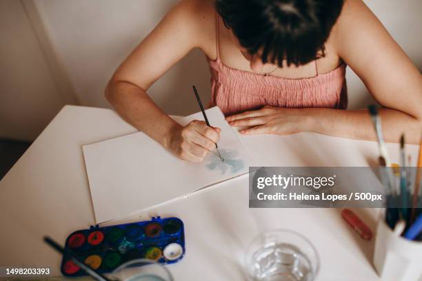 portrait of a young woman painting on paper at table at home,belo horizonte,minas gerais,brazil - aquarela stock pictures, royalty-free photos & images