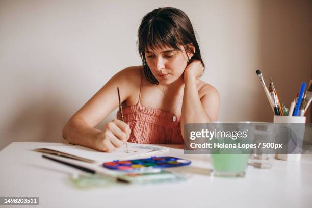 portrait of a young woman painting on paper at table at home,belo horizonte,state of minas gerais,brazil - aquarela stock pictures, royalty-free photos & images