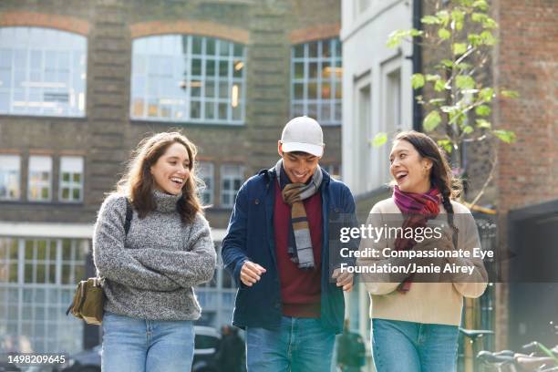 smiling friends on city street - beige trousers stock pictures, royalty-free photos & images