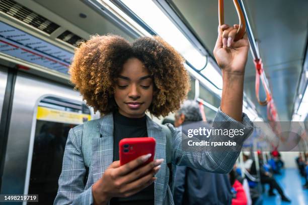 una donna che usa il suo cellulare sull'autobus - metropolitana foto e immagini stock