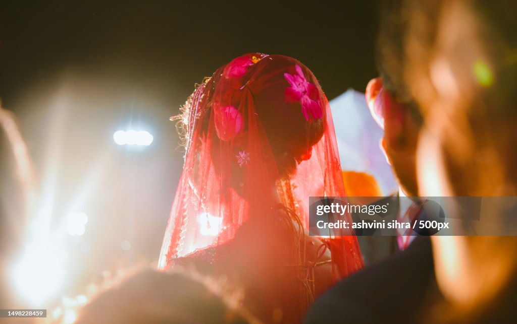 Young couple wearing traditional clothing dancing during wedding ceremony,India