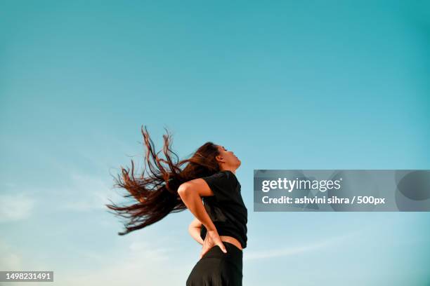 low angle view of woman dancing against sky,india - dance routine stock pictures, royalty-free photos & images