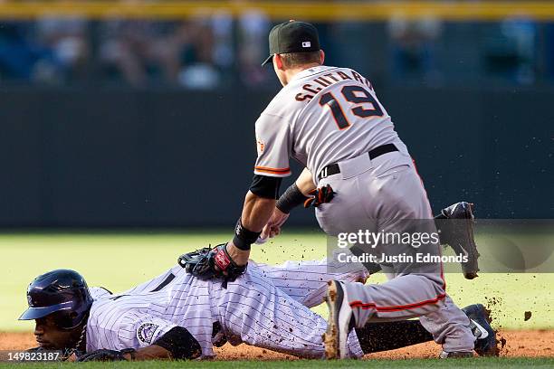 Eric Young Jr. #1 of the Colorado Rockies dives to avoid a tag by Marco Scutaro of the San Francisco Giants as he gets caught in a pickle during the...
