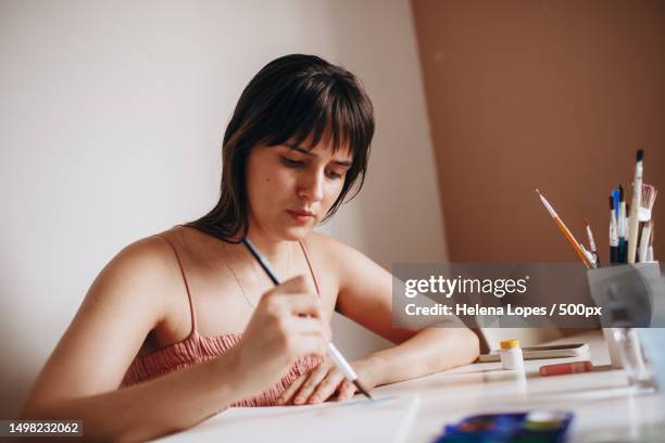 young woman focused on painting paper at table at home,belo horizonte,state of minas gerais,brazil - aquarela stock pictures, royalty-free photos & images