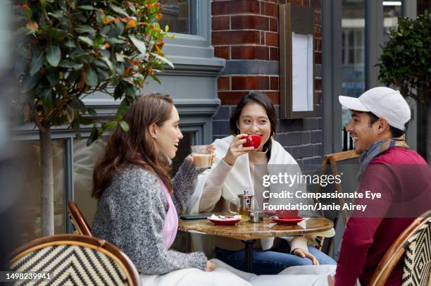 group of friends relaxing at cafe - red hat white people stock pictures, royalty-free photos & images