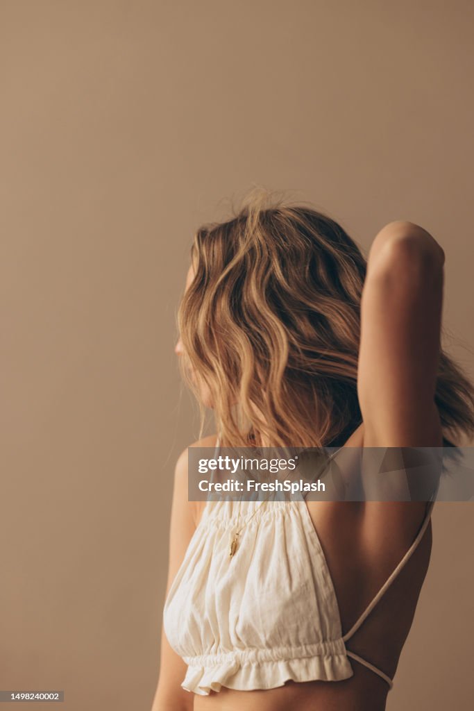 Portrait d’une femme blonde méconnaissable dans un débardeur blanc