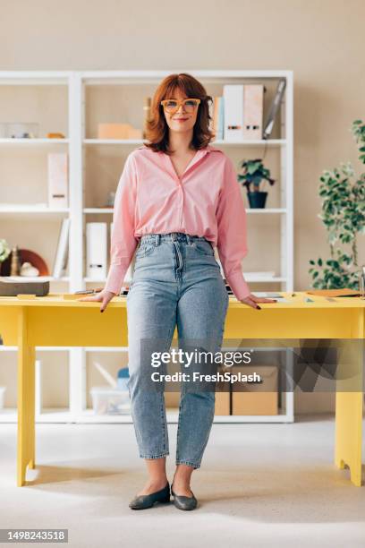 smiling female entrepreneur standing in her office - pink shirt stock pictures, royalty-free photos & images