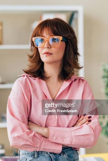 portrait of a successful business woman standing in her office - pink collared shirt stock pictures, royalty-free photos & images