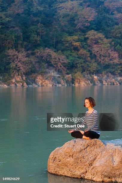 woman meditating / doing yoga outdoors - rishikesh meditation stock pictures, royalty-free photos & images