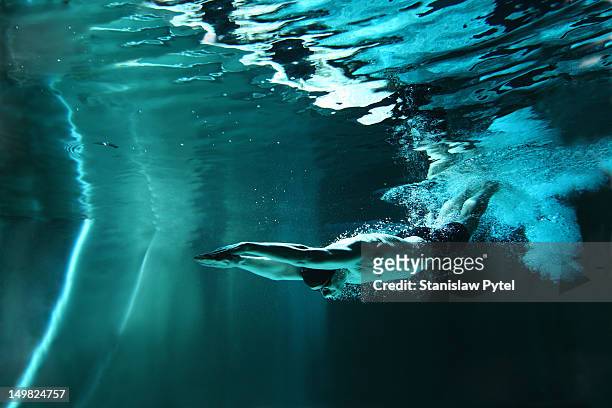 man swimming underwater - diving sport stockfoto's en -beelden