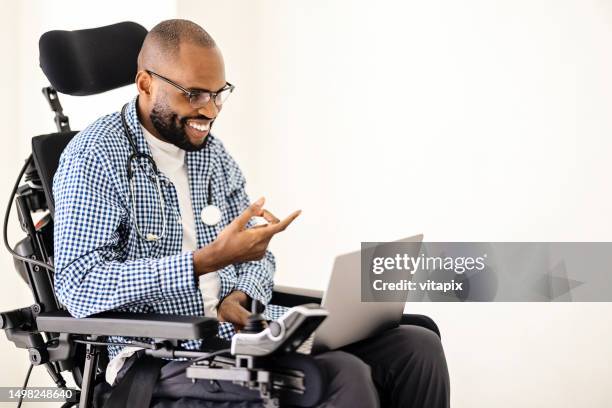 telemedicine - african american doctor working on laptop - man wheel chair stock pictures, royalty-free photos & images