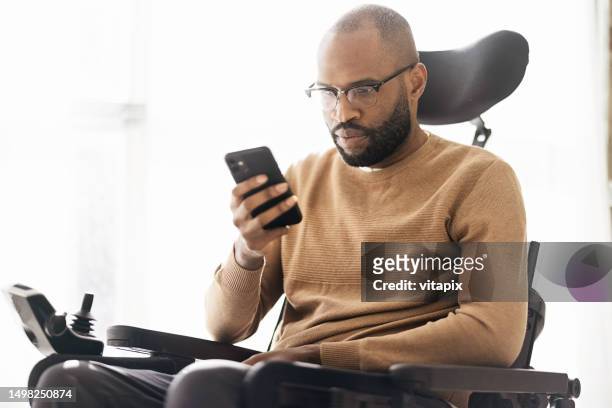 homem negro deficiente usando smartphone em casa - sia - fotografias e filmes do acervo