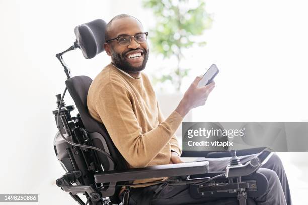 homem negro deficiente usando smartphone em casa - sia - fotografias e filmes do acervo