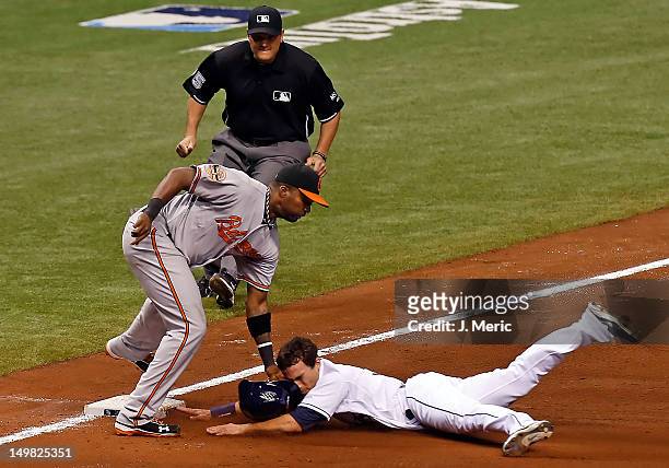 Outfielder Sam Fuld of the Tampa Bay Rays is out at third on a steal attempt as infielder Wilson Betemit of the Baltimore Orioles applies the tag...