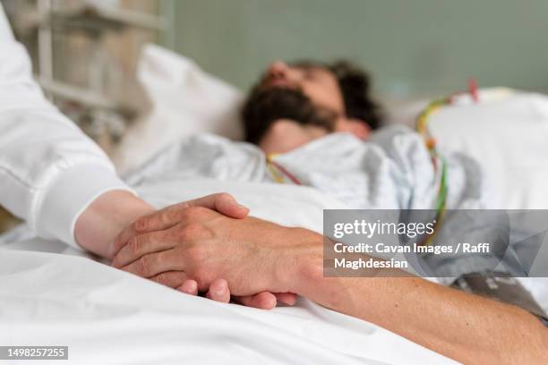 healthcare staff caring for a patient in hospital bed - adult patient stock pictures, royalty-free photos & images