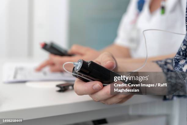 a nurse teaches a patient how to use an insulin pump - insulin pump stock pictures, royalty-free photos & images