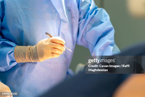 a surgeon holds a scalpel in his hand - scalpel stock pictures, royalty-free photos & images